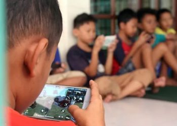 Ilustrasi anak menggunakan media sosial di ponsel