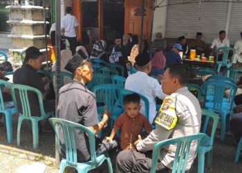 Bhabinkamtibmas Ujung Sabbang menyerahkan bantuan air mineral di rumah duka warga