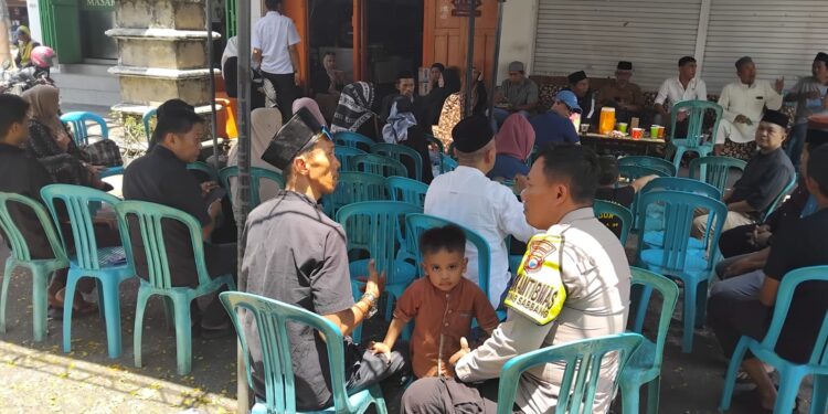 Bhabinkamtibmas Ujung Sabbang menyerahkan bantuan air mineral di rumah duka warga